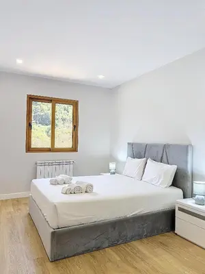 a bedroom with a large white bed with a window at Villa Faísca in São Roque do Faial