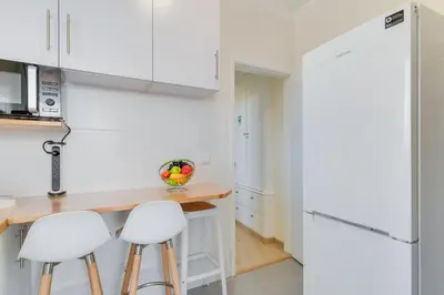 a kitchen with white cabinets and bar stools at Marias Place by Atlantic Holiday in Funchal