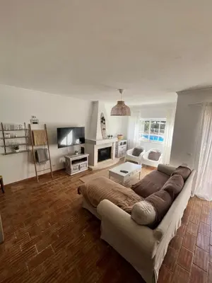 a living room with a large couch and a tv at Casa Da Praia in Luz