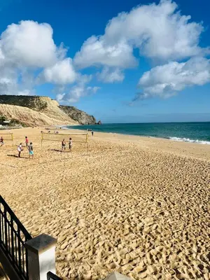 a group of people playing soccer on a sandy beach at Casa Da Praia in Luz