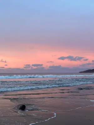 a sunset on the beach with waves at Casa Da Praia in Luz