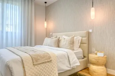 a bedroom with a large bed with white sheets and pillows at The Place by Nicolene, a Home in Madeira in Funchal