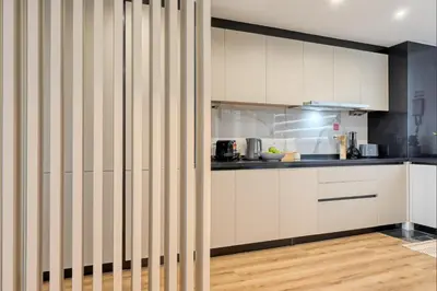 a kitchen with white cabinets and a wooden floor at The Place by Nicolene, a Home in Madeira in Funchal