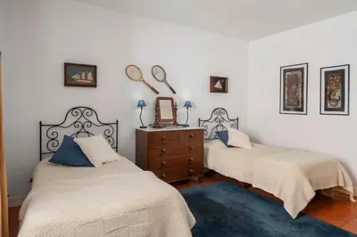 a bedroom with two beds and a dresser with a mirror at Casa do Terreiro by An Island Apart in São Vicente