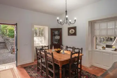 a dining room with a wooden table and chairs at Casa do Terreiro by An Island Apart in São Vicente