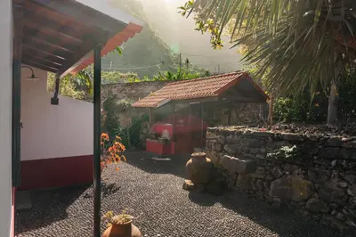 a small building with a stone wall and a roof at Casa do Terreiro by An Island Apart in São Vicente