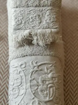 a stack of white towels with a design on them at Profetas GuestHouse in Porto Santo