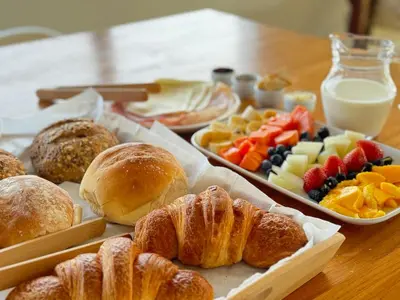 a table with pastries and fruit and plates of food at Profetas GuestHouse in Porto Santo