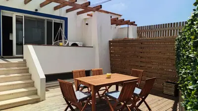 a wooden table and chairs on a patio at Carrapateira Retreat in Carrapateira