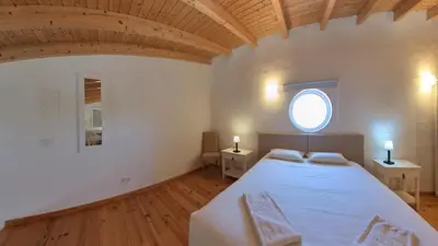 a bedroom with a large bed and a window at Carrapateira Retreat in Carrapateira