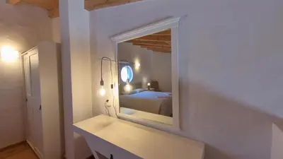 a mirror on a wall in a room with a bed at Carrapateira Retreat in Carrapateira