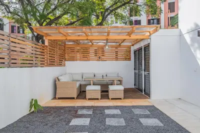 a patio with a table and chairs under a wooden pergola at Cozy Retreat - By WeHost in Funchal