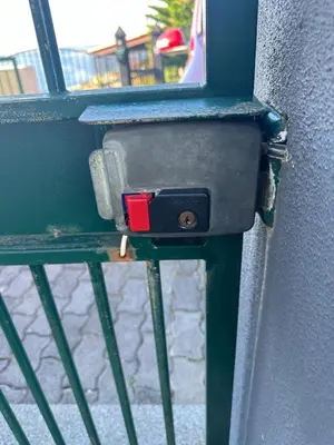 a metal door with a red latch on a wall at NICE and MODERN FLAT NEAR AIRPORT in Santa Cruz