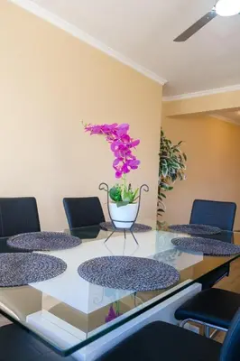 a glass table with a vase with purple flowers on it at GuestReady - One happy stay in Machico in Santa Cruz