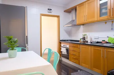 a kitchen with wooden cabinets and a table with chairs at GuestReady - One happy stay in Machico in Santa Cruz