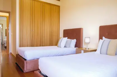 a hotel room with two beds with white sheets at GuestReady - One happy stay in Machico in Santa Cruz