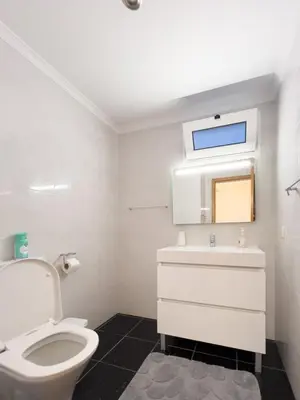 a white bathroom with a toilet and a sink at GuestReady - One happy stay in Machico in Santa Cruz