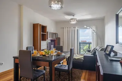 a dining room and living room with a table and chairs at Canico City Center by Zest and Guest in Santa Cruz