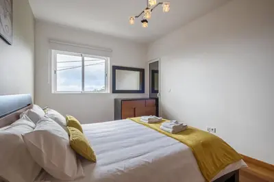 a bedroom with a large white bed with a window at Canico City Center by Zest and Guest in Santa Cruz