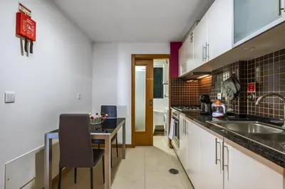 a kitchen with a counter and a sink and a table at Canico City Center by Zest and Guest in Santa Cruz