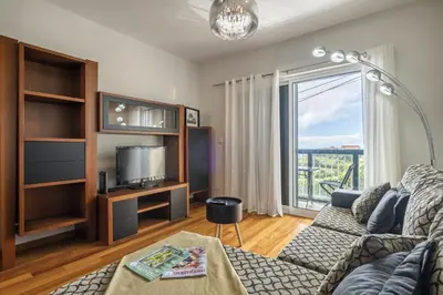 a living room with a couch and a tv at Canico City Center by Zest and Guest in Santa Cruz