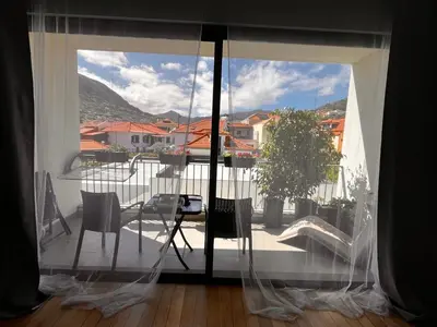 a view of a balcony with a table and chairs at Apartment Machico near the beach in Machico