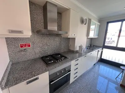 a kitchen with white cabinets and a stove top oven at Apartment Machico near the beach in Machico