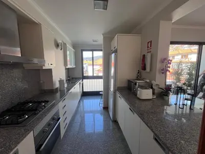 a kitchen with white cabinets and granite counter tops at Apartment Machico near the beach in Machico
