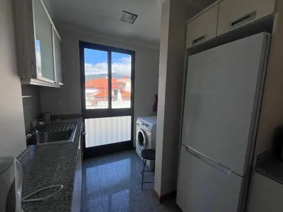 a kitchen with a white refrigerator and a window at Apartment Machico near the beach in Machico
