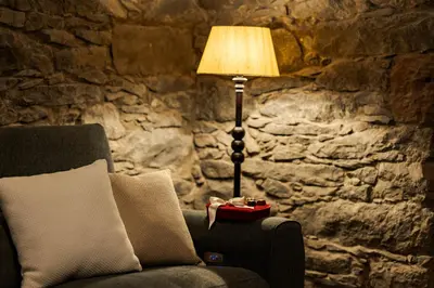 a lamp sitting next to a chair with a pillow at Du.Val - Madeira Valley Villa in Ribeira Brava