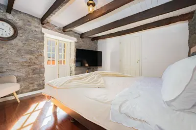 a bedroom with a large bed and a clock on the wall at Du.Val - Madeira Valley Villa in Ribeira Brava