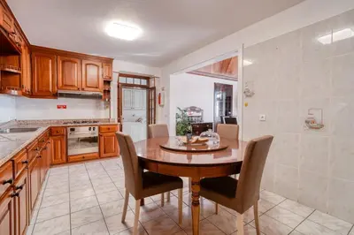 a kitchen with a wooden table and chairs at Casa Lucas by Stay Madeira in Ponta do Sol
