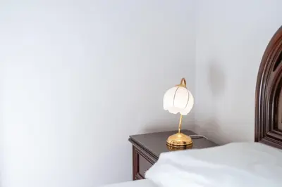 a lamp on a table next to a bed at Casa Lucas by Stay Madeira in Ponta do Sol