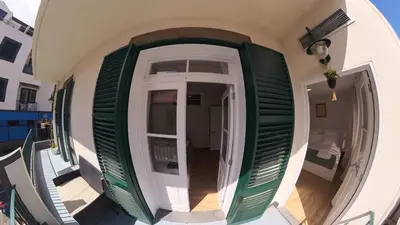 a hallway of a house with green and white shutters at Machico Heart Suites in Machico