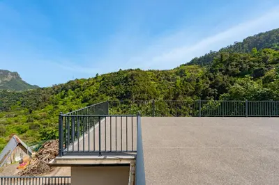 a balcony with a gate with a mountain in the background at Casa da Quebrada in Santana