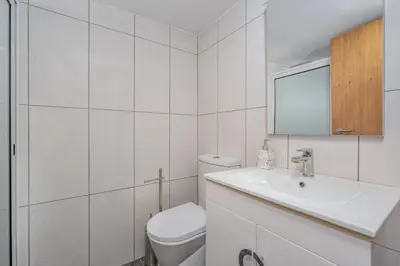 a white bathroom with a toilet and a sink at Casa da Quebrada in Santana