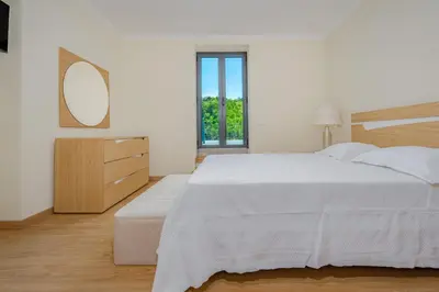 a white bedroom with a large bed and a mirror at Casa da Quebrada in Santana