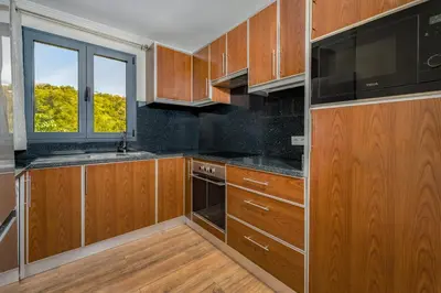 a kitchen with wooden cabinets and a window at Casa da Quebrada in Santana