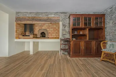 a living room with a brick fireplace and a chair at Casa da Quebrada in Santana