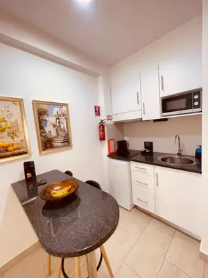 a kitchen with a table with a bowl of fruit on it at Esmeralda Holidays Apartments in Funchal