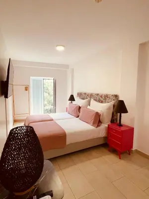 a hallway with white walls and tiled floors at Esmeralda Holidays Apartments in Funchal
