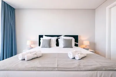 a bedroom with a large white bed with towels on it at Villa Ocean Haven by AH in Ribeira Brava