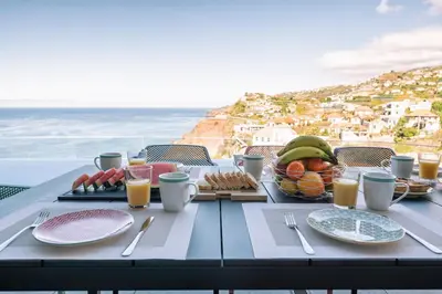 a table with food and a view of the ocean at Villa Ocean Haven by AH in Ribeira Brava