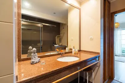 a bathroom with a sink and a large mirror at GuestReady - Madeiran paradise with ocean view in Funchal