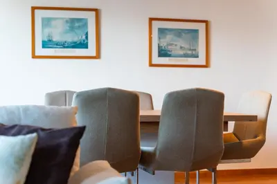 a dining room table with chairs and paintings on the wall at GuestReady - Madeiran paradise with ocean view in Funchal