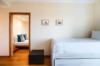 a bedroom with a white bed and a mirror at GuestReady - Madeiran paradise with ocean view in Funchal