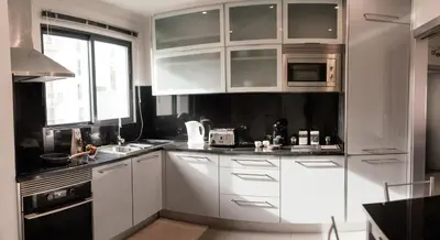 a white kitchen with white cabinets and a window at Luxurious Lido-Sun Island X1V Apt.Free parking in Funchal