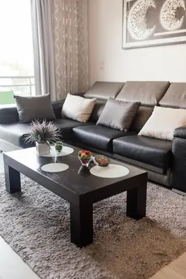 a living room with a black couch and a coffee table at Luxurious Lido-Sun Island X1V Apt.Free parking in Funchal
