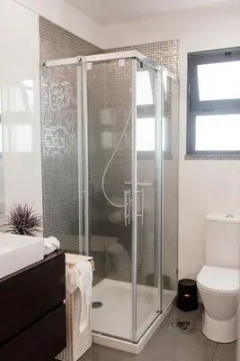 a bathroom with a shower with a glass door at Luxurious Lido-Sun Island X1V Apt.Free parking in Funchal