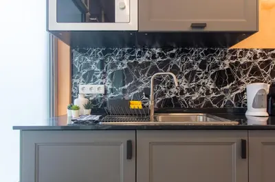 a kitchen with gray cabinets and a black counter top at Social Lodge Hollywood Studios in Funchal
